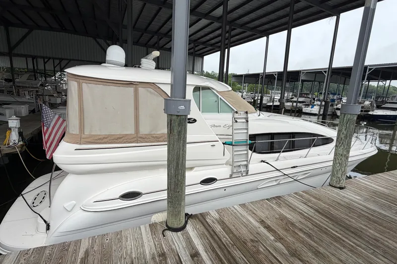 Slide: The Image of 2002 Sea Ray 480 Motor Yacht docked in a marina, featuring sleek design and American flag. - 2