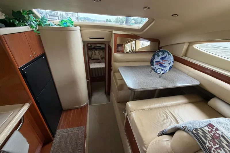 Slide: The Image of Interior of 2002 Sea Ray 480 Motor Yacht with dining area and cozy seating. - 27