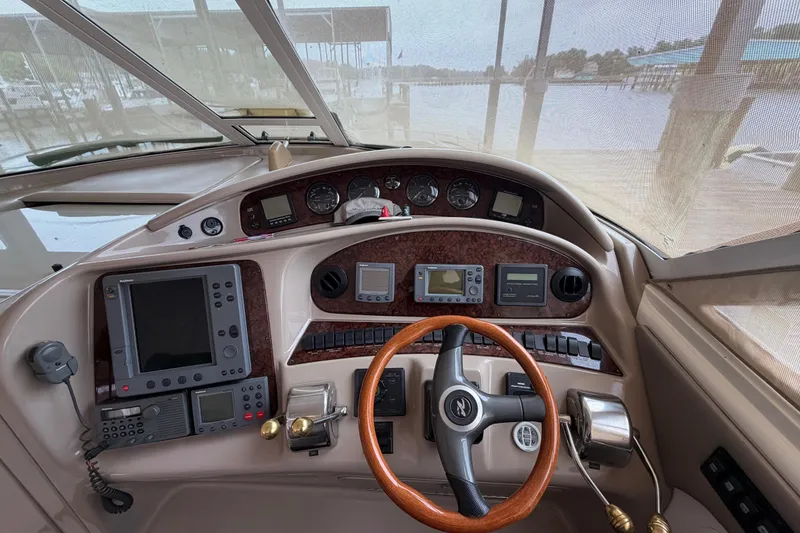 Slide: The Image of Cockpit of 2002 Sea Ray 480 Motor Yacht with navigation instruments and wooden steering wheel. - 13