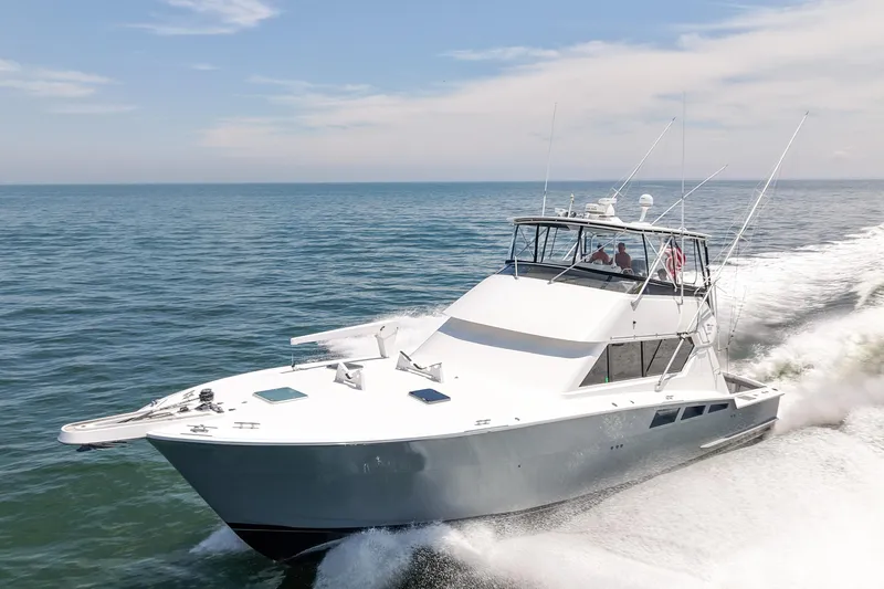 The Image of 1995 Hatteras 54 Convertible yacht cruising on open water. - 1