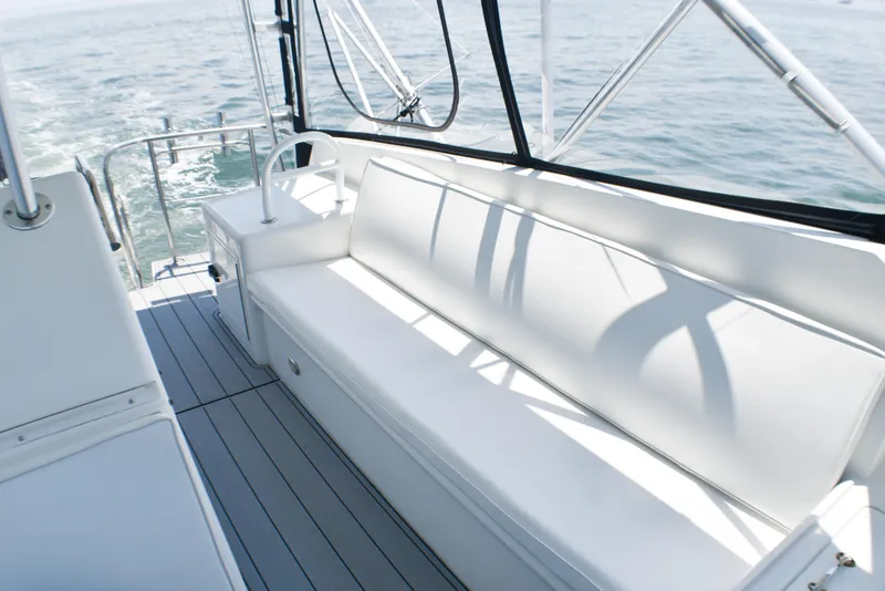 Slide: The Image of 1995 Hatteras 54 Convertible yacht deck with white seating and ocean view. - 23