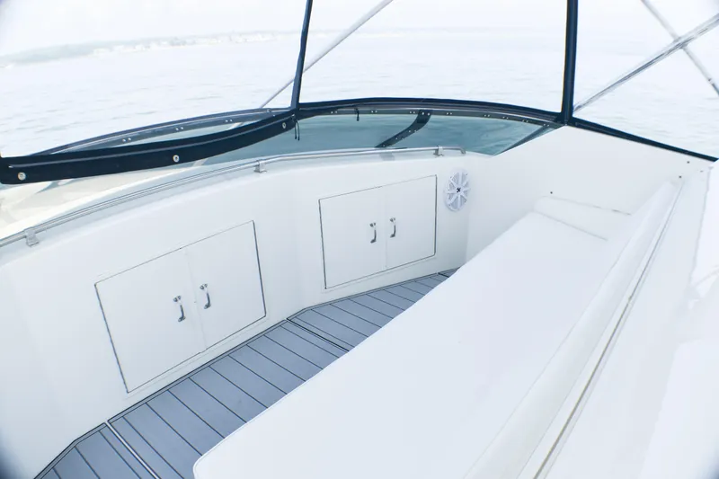 Slide: The Image of 1995 Hatteras 54 Convertible yacht interior with seating and storage, overlooking calm waters. - 24