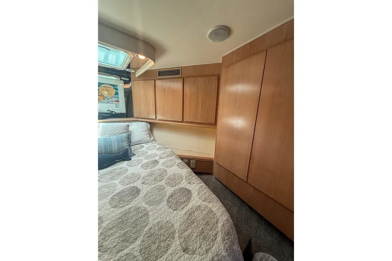 Slide: The Image of Interior cabin of 1995 Hatteras 54 Convertible yacht with wooden cabinetry and cozy bedding. - 41