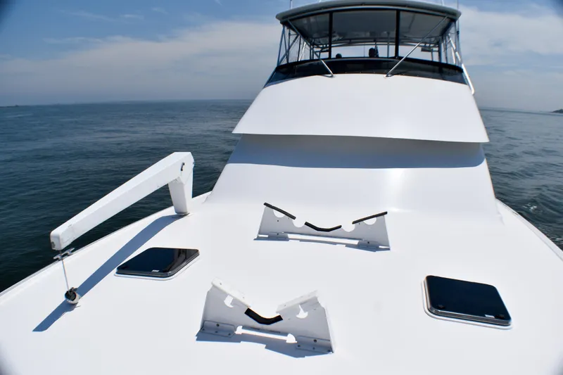 Slide: The Image of 1995 Hatteras 54 Convertible yacht on open water, showcasing sleek deck design. - 14