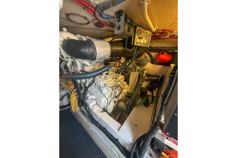 Slide: The Image of Engine room of 1995 Hatteras 54 Convertible yacht, showcasing mechanical components and control panel. - 53