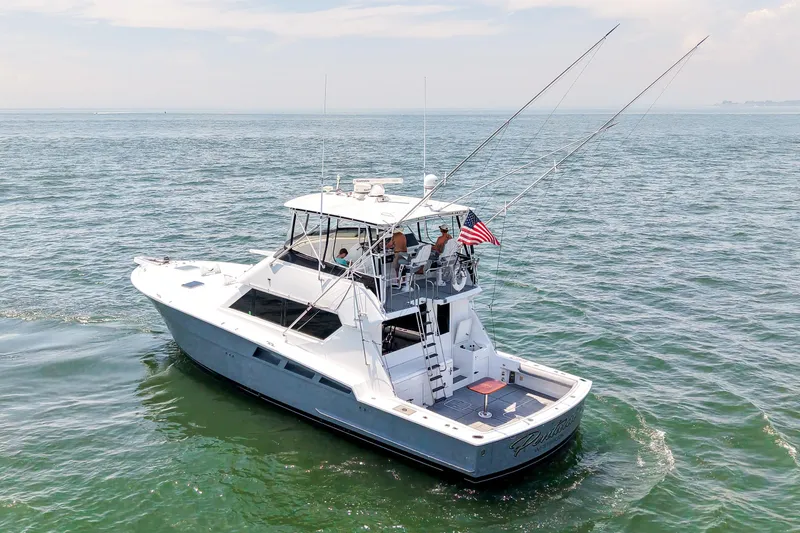 Slide: The Image of 1995 Hatteras 54 Convertible yacht cruising on open water with fishing rods. - 6