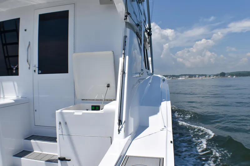 Slide: The Image of 1995 Hatteras 54 Convertible yacht cruising on a sunny day, showcasing sleek design and open water. - 18