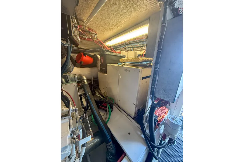 Slide: The Image of Engine room of 1995 Hatteras 54 Convertible yacht, showcasing equipment and wiring. - 54