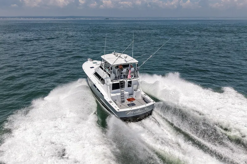 Slide: The Image of 1995 Hatteras 54 Convertible yacht cruising on open water. - 28