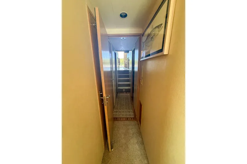 Slide: The Image of Hallway inside 1995 Hatteras 54 Convertible yacht, featuring wooden doors and carpeted flooring. - 42