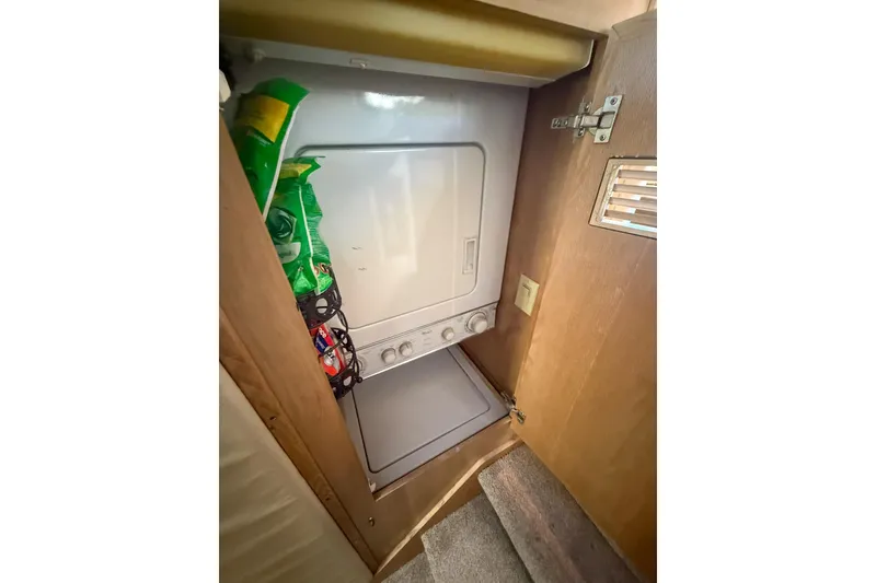 Slide: The Image of Laundry area inside 1995 Hatteras 54 Convertible yacht with stacked washer and dryer. - 43