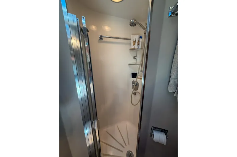Slide: The Image of Shower area in 1995 Hatteras 54 Convertible yacht, featuring modern fixtures and storage shelves. - 37