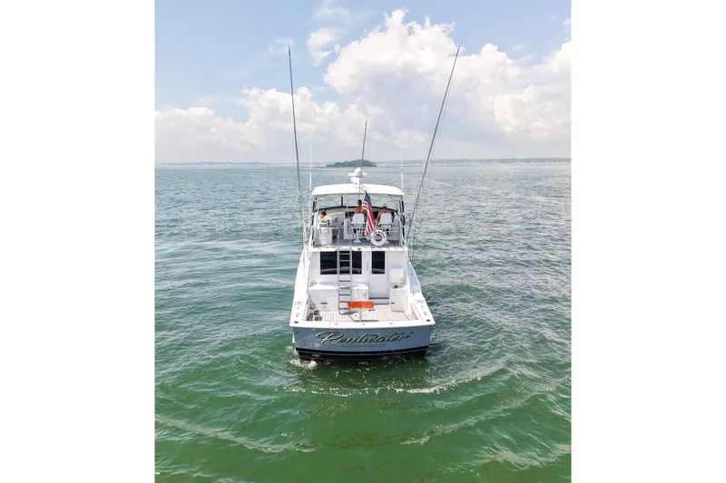 Slide: The Image of 1995 Hatteras 54 Convertible yacht on open water under a cloudy sky. - 12
