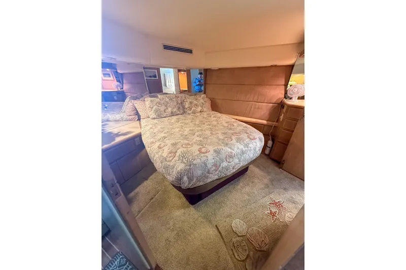 Slide: The Image of Cozy bedroom interior of 1995 Hatteras 54 Convertible yacht with patterned bedding. - 33