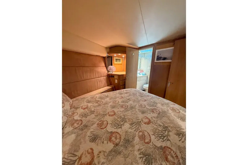 Slide: The Image of Cozy bedroom interior of 1995 Hatteras 54 Convertible yacht with patterned bedding. - 34