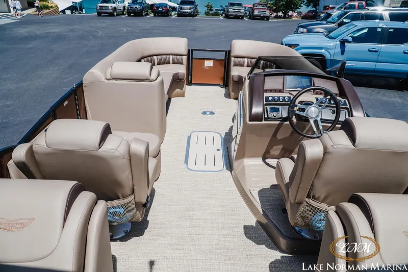 Slide: The Image of 2024 Bennington 24LXSFB pontoon boat interior with beige seating and modern dashboard. - 9