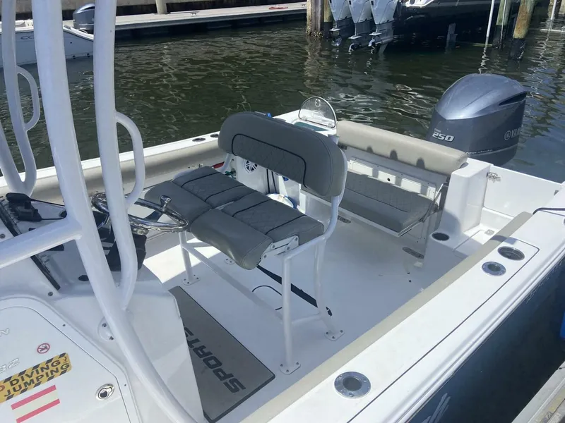 Slide: The Image of 2022 Sportsman Open 232 Center Console boat with seating and outboard motor at dock. - 22