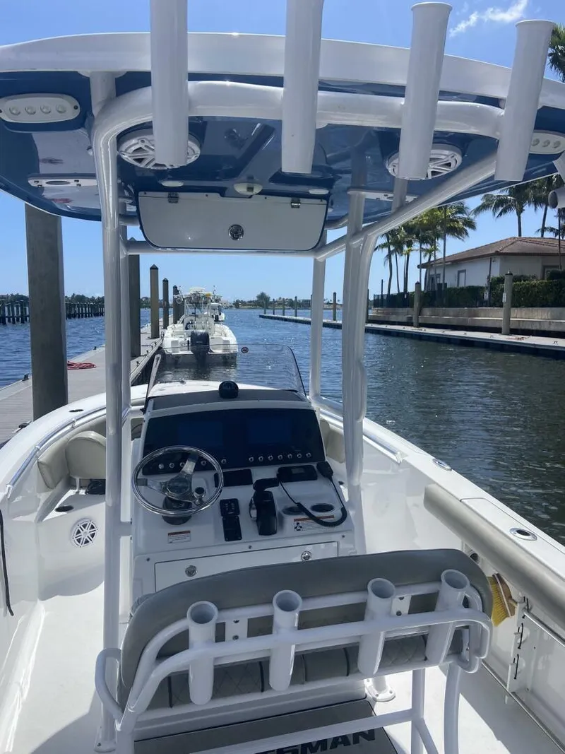 Slide: The Image of 2022 Sportsman Open 232 Center Console boat docked by a waterfront. - 20