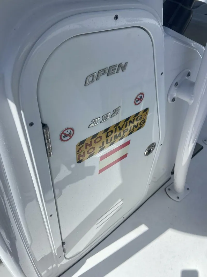Slide: The Image of 2022 Sportsman Open 232 Center Console boat door with safety warnings. - 17
