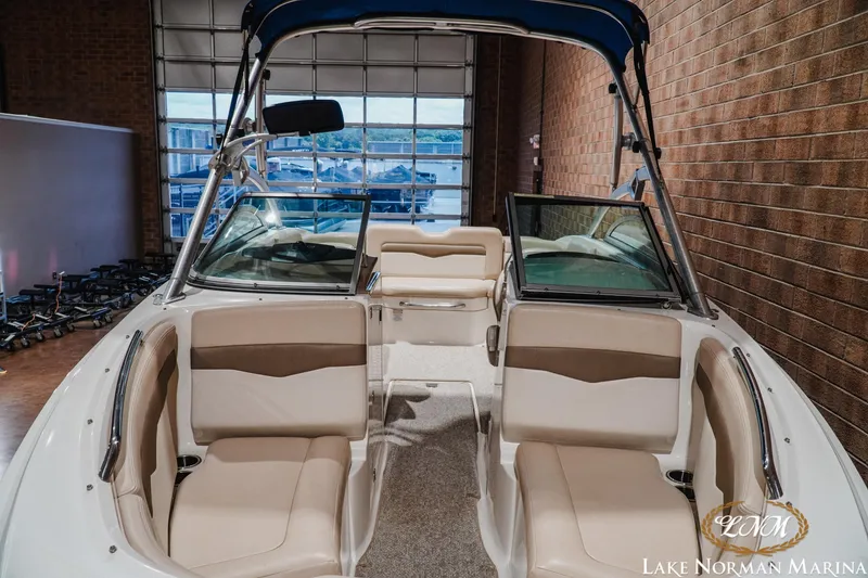 Slide: The Image of 2011 Chaparral 246 SSi boat interior with beige seating, displayed at Lake Norman Marina. - 6
