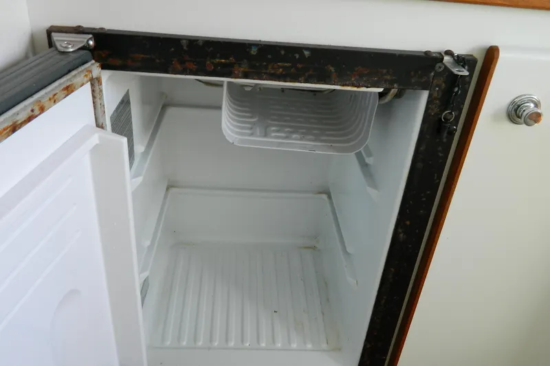 Slide: The Image of Open refrigerator inside a 1999 Tiara Yachts 2900 Coronet boat, showing interior details. - 8