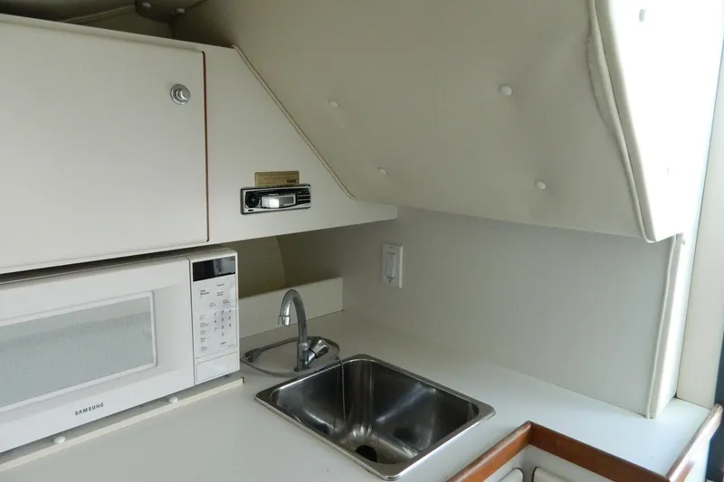 Slide: The Image of 1999 Tiara Yachts 2900 Coronet interior with sink and microwave in compact kitchen area. - 6