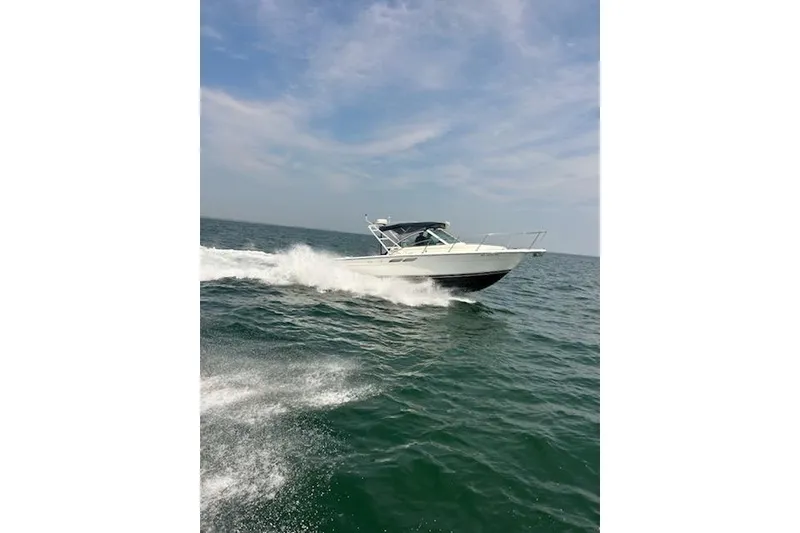Slide: The Image of 1999 Tiara Yachts 2900 Coronet cruising on open water under a clear sky. - 17