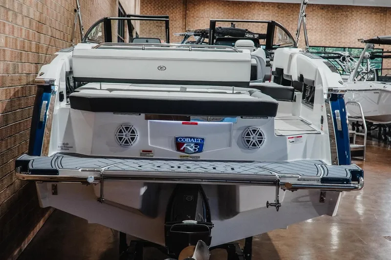 Slide: The Image of 2024 Cobalt R8 boat in showroom, showcasing rear seating and swim platform. - 7
