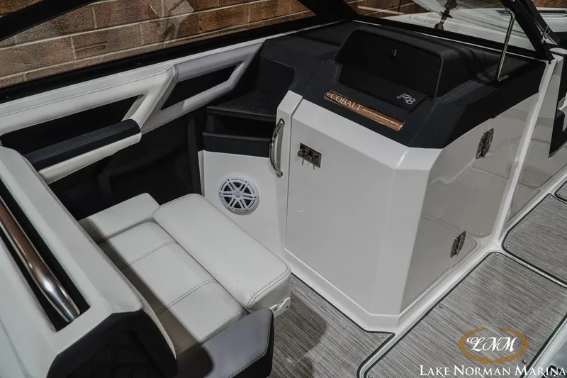 Slide: The Image of 2024 Cobalt R8 boat interior with sleek white seating and modern dashboard design. - 18