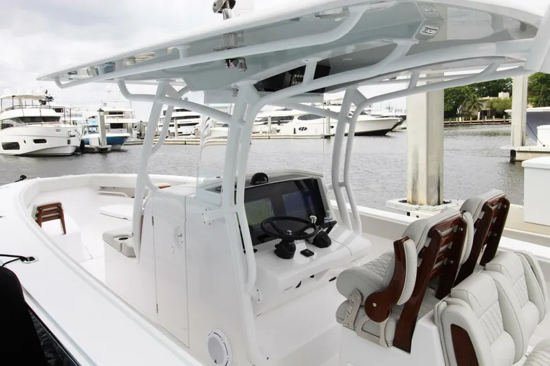 Slide: The Image of 2024 Jupiter 34 HFS boat interior with helm, seating, and marina view. - 3