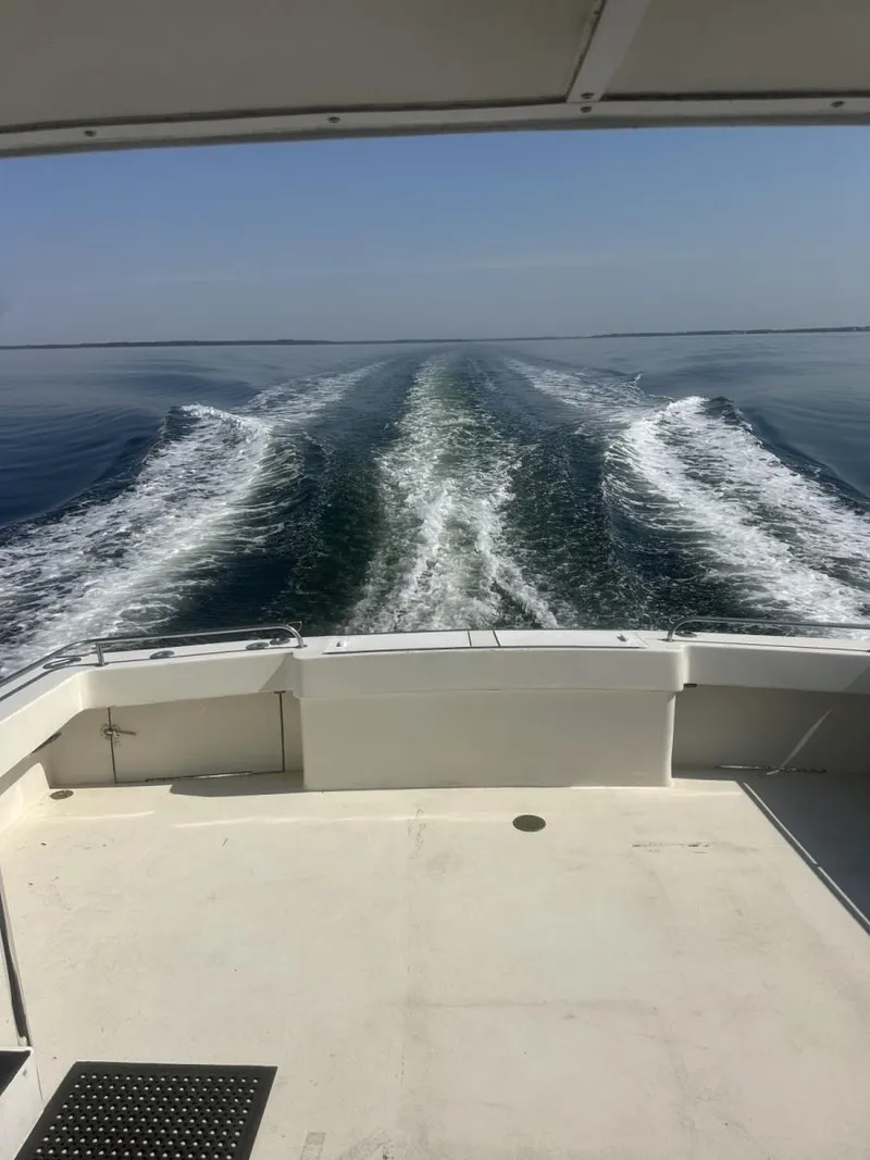 Slide: The Image of 1987 Miller Sportfish 55 cruising, leaving a wake on calm ocean waters. - 5