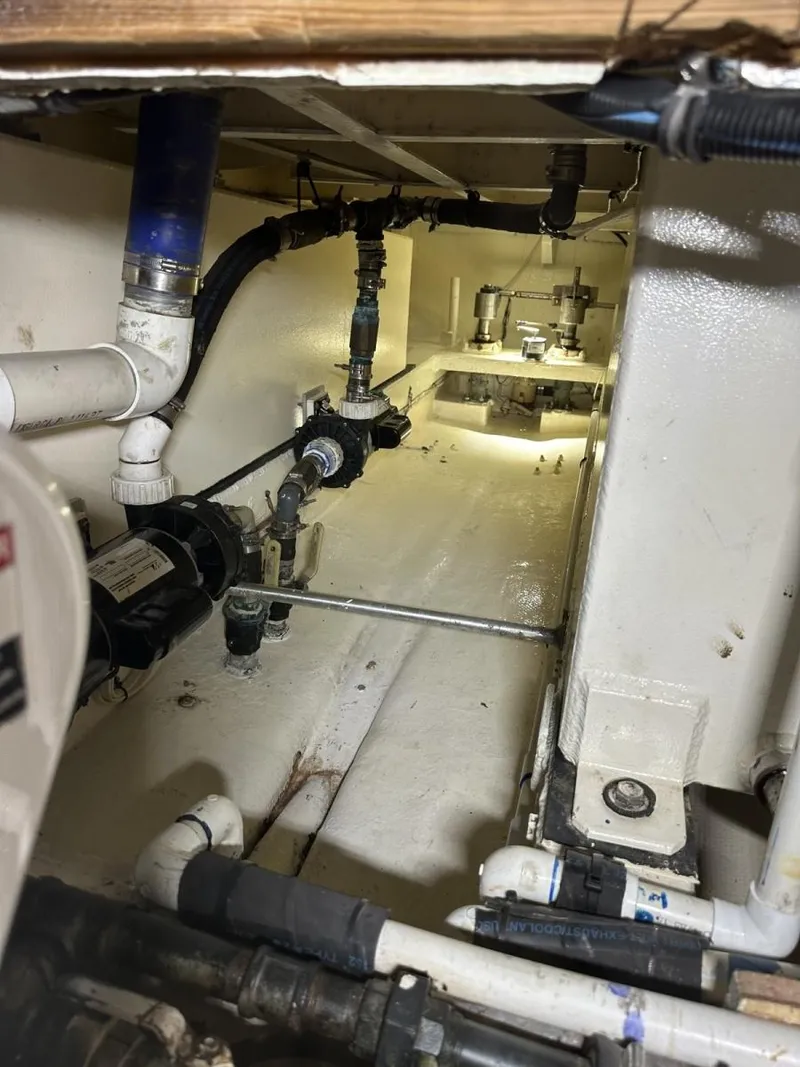 Slide: The Image of Engine room of a 1987 Miller Sportfish 55 boat, showcasing plumbing and mechanical components. - 10