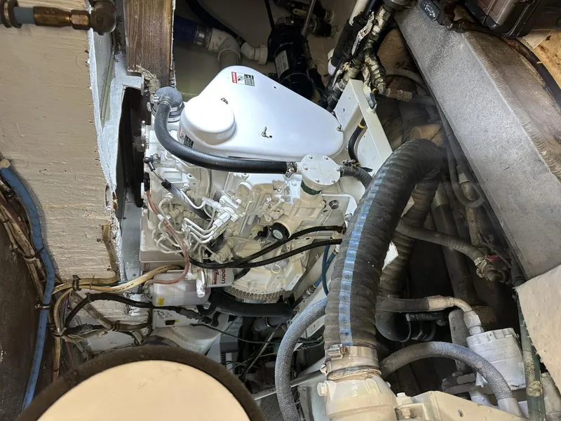 Slide: The Image of Engine room of a 1987 Miller Sportfish 55 boat, showcasing mechanical components and hoses. - 11