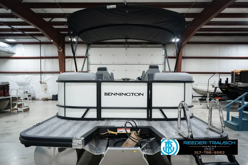 Slide: The Image of 2027 Bennington 22 SSR pontoon boat in a showroom with canopy and ladder. - 9