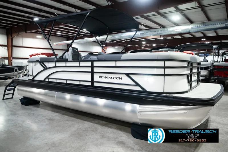 Slide: The Image of 2027 Bennington 22 SSR pontoon boat displayed indoors at Reeder-Trausch Marine showroom. - 5