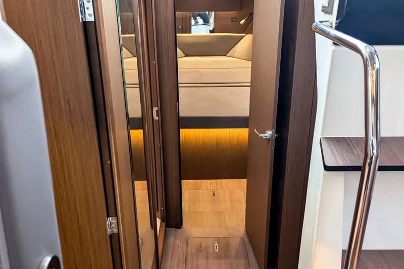 Slide: The Image of Interior view of 2021 Beneteau America Antares 11, featuring wood finishes and cozy cabin space. - 9