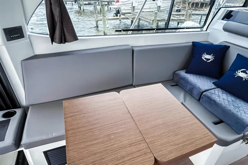 Slide: The Image of Interior of 2021 Beneteau America Antares 11 with cozy seating and wooden table. - 8