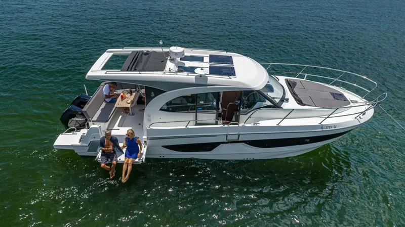 Slide: The Image of Aerial view of a 2021 Beneteau Antares 11 on calm water with people on board. - 16
