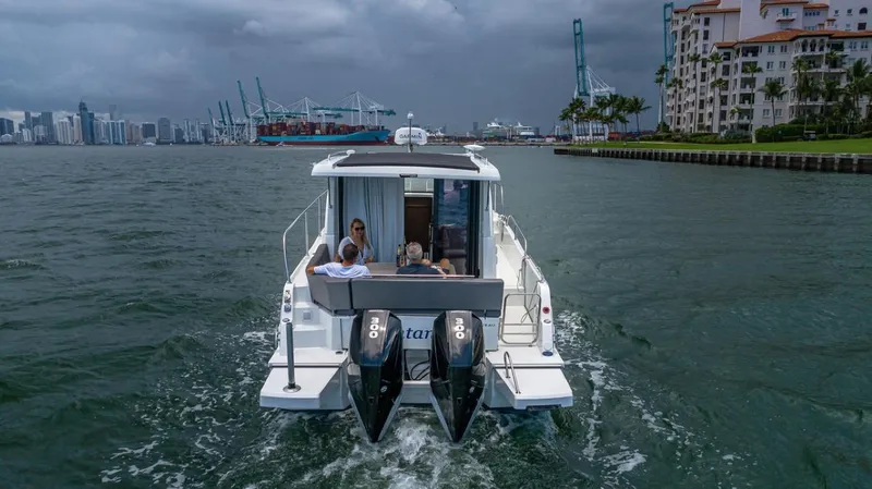 Slide: The Image of 2021 Beneteau Antares 11 cruising on a waterway in a city with a harbor. - 15