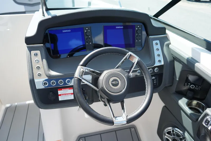 Slide: The Image of 2025 Chaparral 270 OSX boat dashboard with dual Simrad displays and steering wheel. - 7