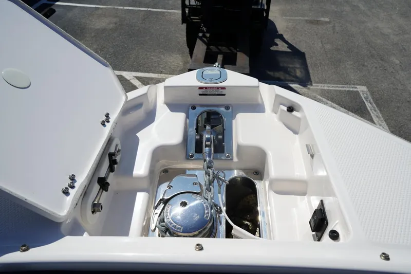 Slide: The Image of 2025 Chaparral 270 OSX boat anchor compartment with open hatch and visible winch system. - 11