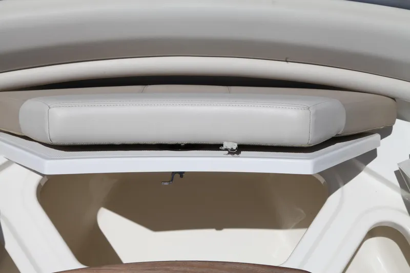 Slide: The Image of 2019 Boston Whaler 380 Outrage boat seating detail with white cushion and storage compartment. - 60