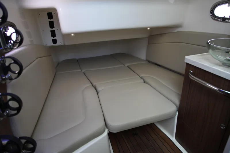 Slide: The Image of 2019 Boston Whaler 380 Outrage cabin interior with beige seating and wooden cabinetry. - 53