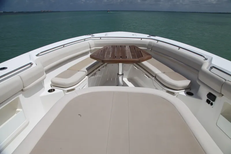 Slide: The Image of 2019 Boston Whaler 380 Outrage boat interior with seating and table on calm water. - 19