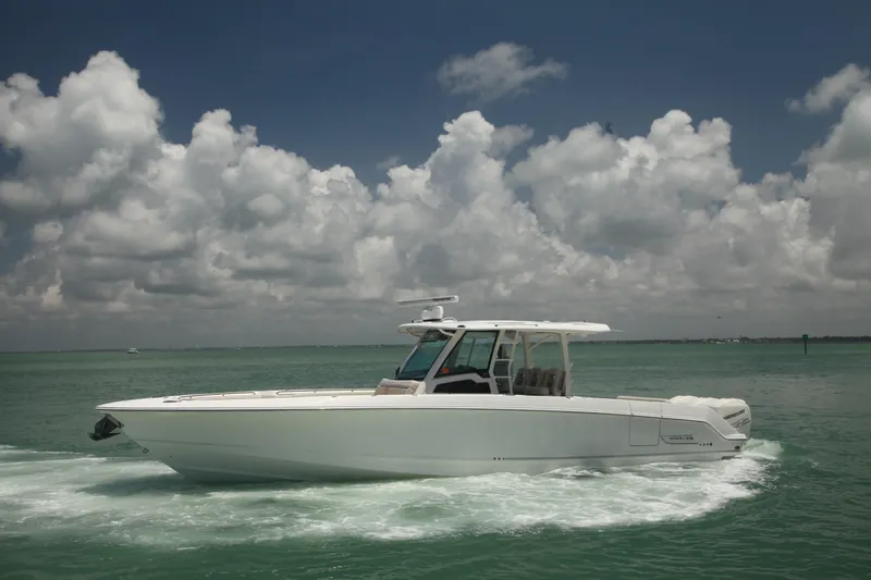 Slide: The Image of 2019 Boston Whaler 380 Outrage cruising on open water under cloudy sky. - 4