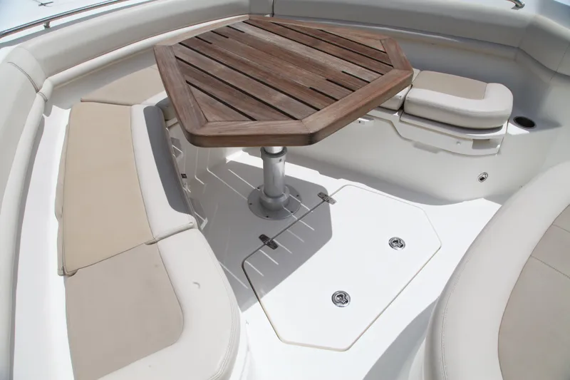Slide: The Image of 2019 Boston Whaler 380 Outrage boat interior with wooden table and cushioned seating. - 20