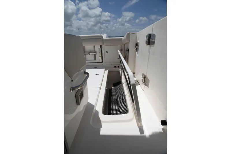 Slide: The Image of 2019 Boston Whaler 380 Outrage deck with storage compartment under cloudy sky. - 37