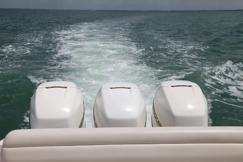 Slide: The Image of Triple outboard engines on a 2019 Boston Whaler 380 Outrage cruising through open water. - 40