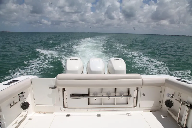 Slide: The Image of 2019 Boston Whaler 380 Outrage cruising on open water, view from the stern. - 39