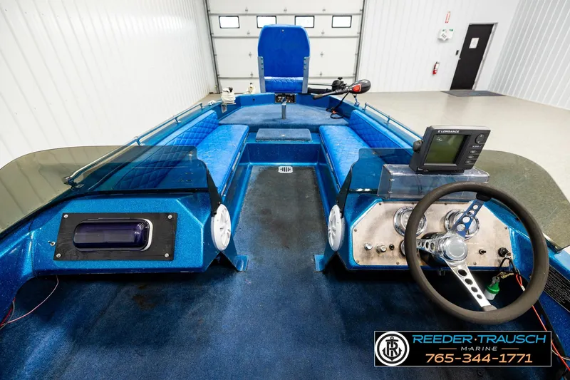 Slide: The Image of 1980 Ranger 175 VS boat interior with blue seating and steering console. - 12